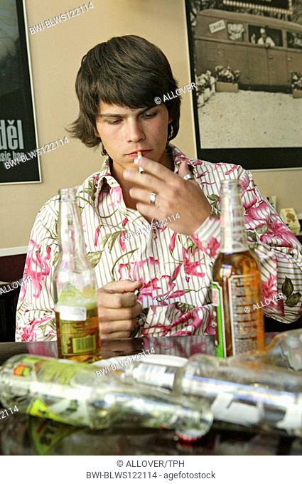 young man drinking alcohol at a pub