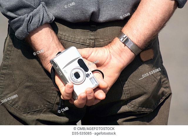 Tourist holding camera in his hands