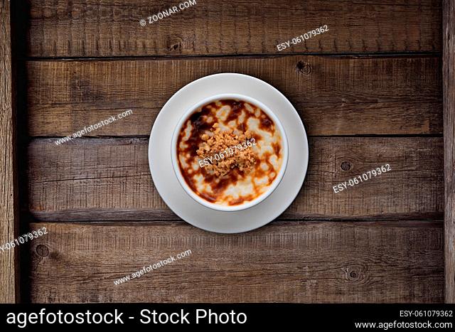 Top view of traditional tukish rice pudding with walnut isolated on rustic wooden table