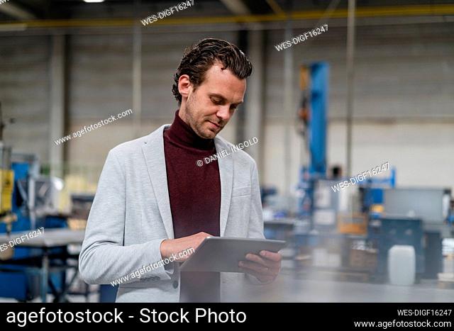 Mid adult businessman using digital tablet at industry