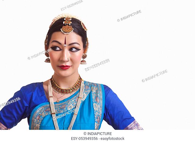 Beautiful Bharatanatyam dancer looking sideways over white background