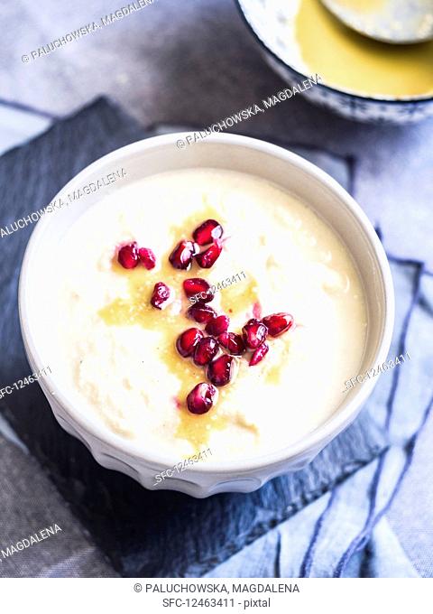 Cream of cauliflower soup with pomegranate seeds and tahina sauce