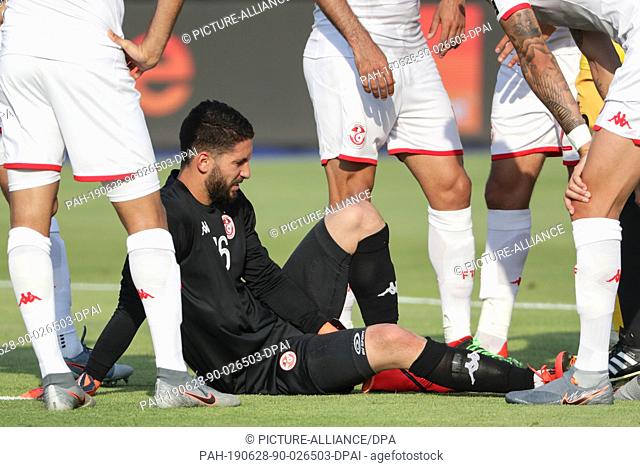 28 June 2019, Egypt, Suez: Tunisia's goalkeeper Mouez Hassen lies on the pitch during the 2019 Africa Cup of Nations Group E soccer match between Tunisia and...