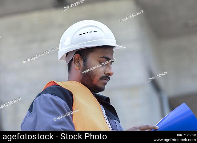 Young technician with beard working outside with helmet, Baden-Württemberg, Germany, Europe