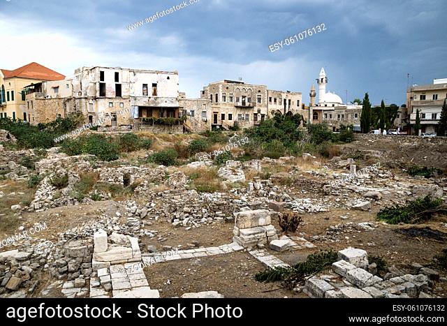 Cityscape with mosque and ruins with dark dramatic cloudscape in Tyre, Sour, Lebanon