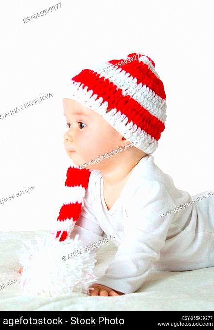 little baby in knitted red whitey hat on red blanket