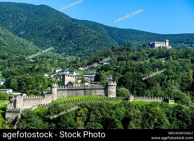 Switzerland, Ticino, Bellinzona, Montebello castle with green forested mountains in background