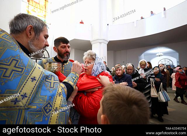 RUSSIA, LUGANSK - OCTOBER 14, 2023: Archpriest Konstantin Sumtsov (L front) administers the Eucharist during a service at the Church of Our Lady of Tenderness...