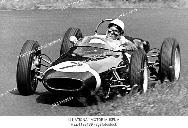 Stirling Moss taking a bend in a racing car, (c1960-c1961?). Moss began his career in 1947 driving a BMW 328. In 1955 he won his first Grand Prix at Aintree...