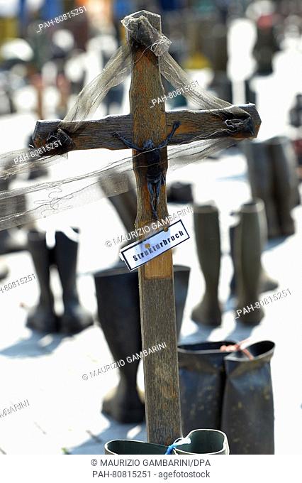 Activists with the Federal Association of German Dairy Cattle Owners (BDM) have erected a wooden cross written with 'structural break' and rubber boots at the...