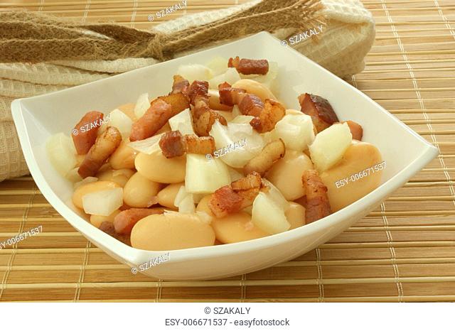 white bean salad in bowl with onion and bacon