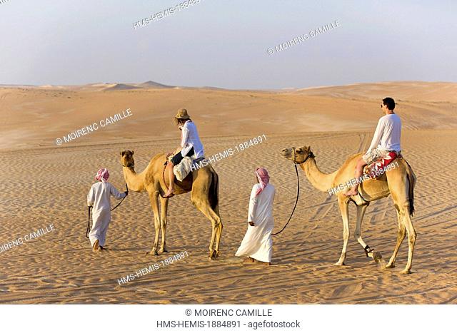 Sultanate of Oman, Ash Sharqiyyah region, Wahiba Sands, Qihayd, tourists on a camel