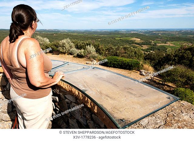 Europe, France, Languedoc-Roussillon - a tourist looks out from a viewing platform on an old windmill in the Haut Languedoc Natural Park near Faugeres