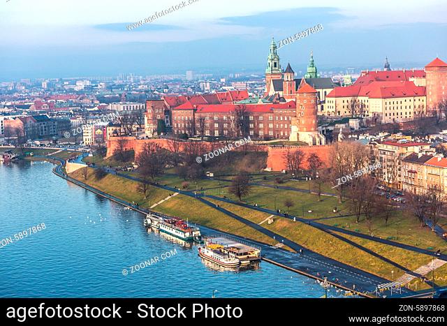Historic royal Wawel castle in Cracow, Poland with park and Vistula river. Aerial view at sunset