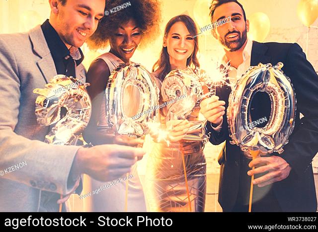 Men and women celebrating the new year 2020 with sparklers and wine