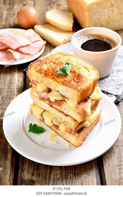 Breakfast with cheese sandwich and coffee on wooden table, country style