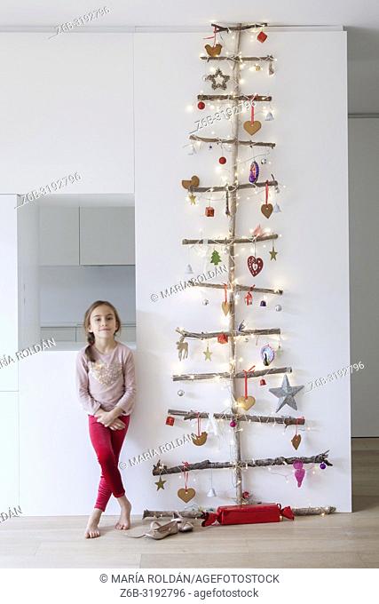 Portrait of a little girl standing by a Christmas tree