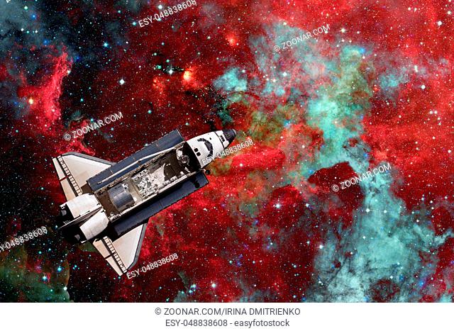Space Shuttle over galaxy and space nebula. Elements of this image furnished by NASA
