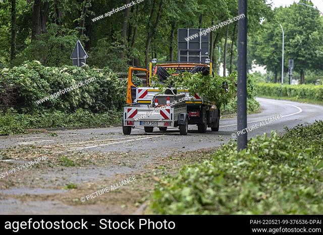 21 May 2022, North Rhine-Westphalia, Lippstadt: A vehicle from the city's public works department stands on a closed street where leaves and branches are being...