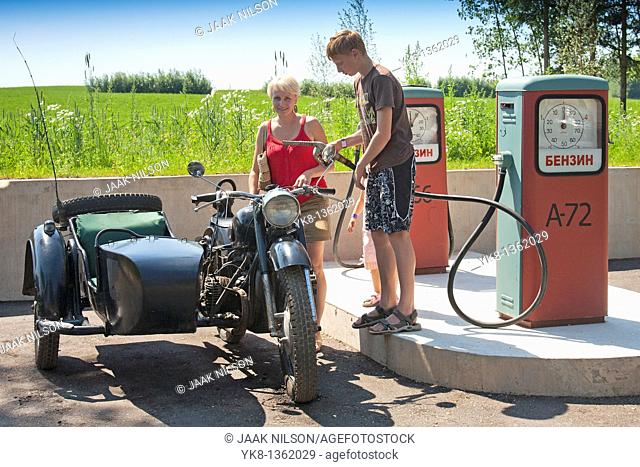 Teenage Boy Refilling Old Sidecar Motorcycle in Gas Station, Estonian Road Museum, Estonia