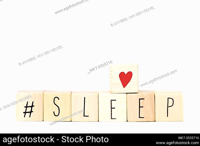 Wooden cubes with a Hashtag and the word Sleep isolated on white background, social media concept space for text close-up