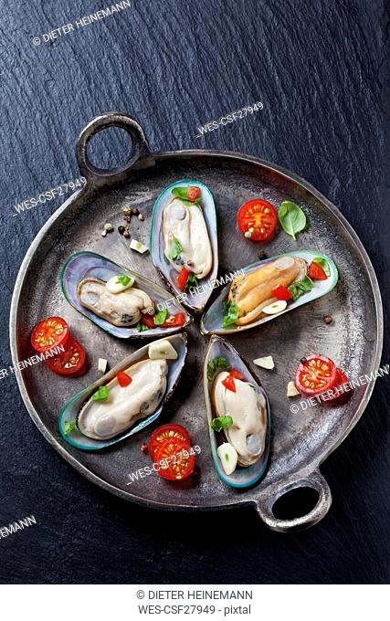 Green mussels with tomatoes, capsicum and garlic, in iron pan