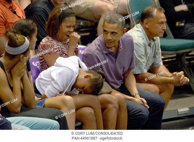 Sasha Obama rests her head on her legs as her dad, United States President Barack Obama, first lady Michelle Obama and sister Malia Obama attend the Hawaiian...