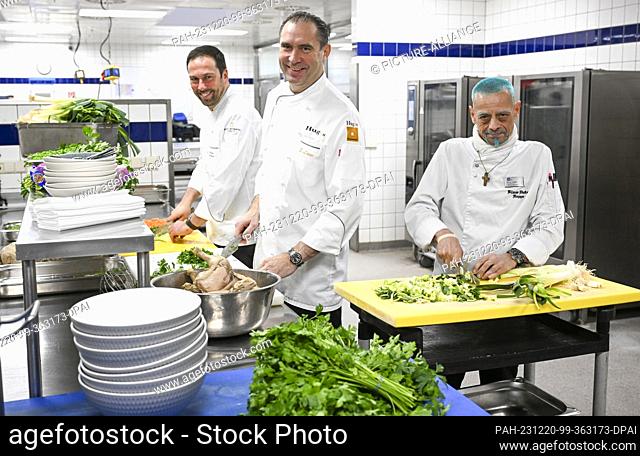 20 December 2023, Berlin: InterContinental head chef Henning Drenkhahn (l-r), Michelin-starred chef Eberhard Lange and City Mission chef Klaus Hoppe cook for...