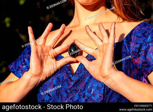 Picture taken on a very sunny autumn day. Sacred yoni is placed to her heart as an empowerment symbol