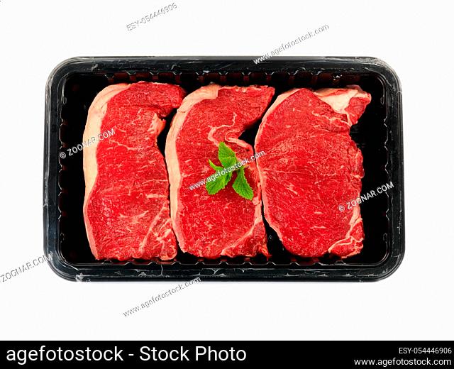 Supermarket packaged porterhouse steaks isolated against a white background