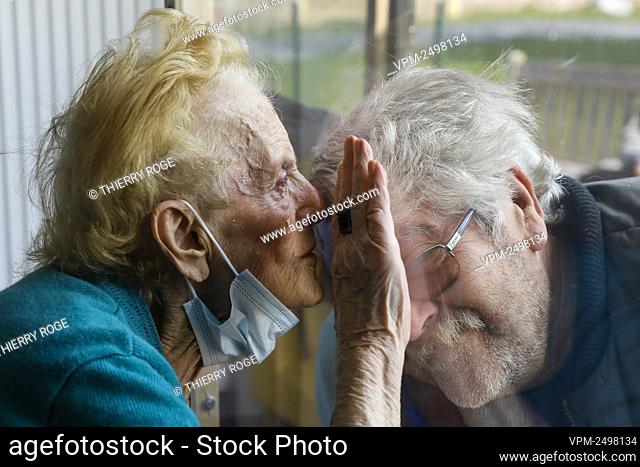 Illustration picture shows a resident kissing a visitor through plexiglass, as the visits to residents of rest homes are possible from today in Wallonia