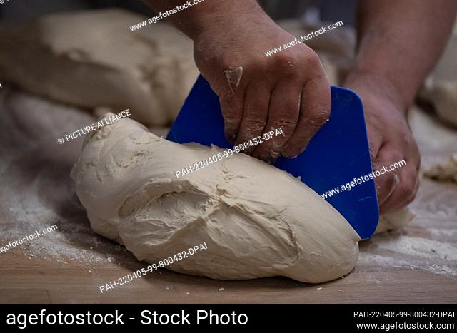05 April 2022, Lower Saxony, Göttingen: A baker cuts dough in the bakery of ""Der Göttinger Feuerbäcker"". The cost increases for energy