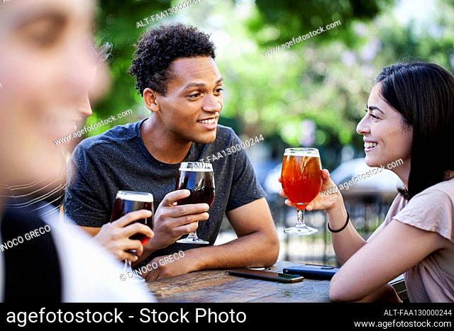 Latin American man enjoying a beer with friends