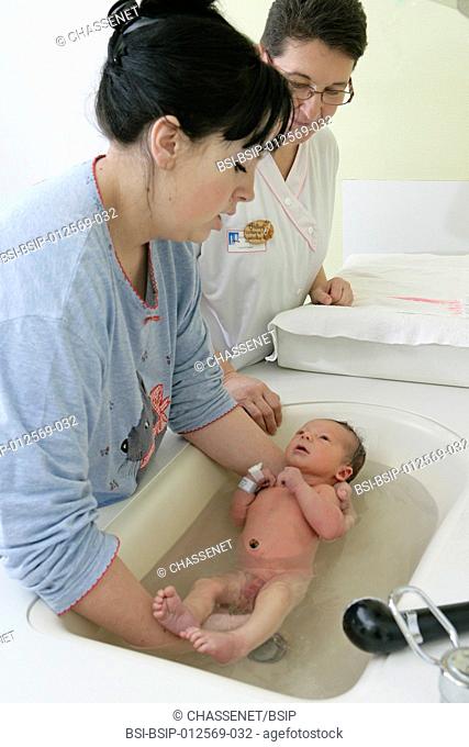 Photo essay at the maternity of Rouen hospital, France. Nursery. Child care aid explains to the young mother how to make the daily care and the toilet of the...