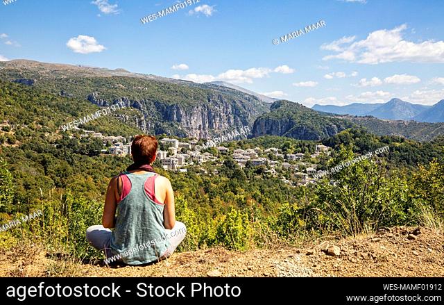 Greece, Epirus, Zagori, Female hiker admiring forest surrounding village in¶ÿVikos-Aoos¶ÿNational Park during summer
