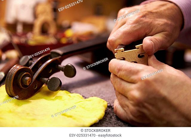 Close Up Of Man Restoring Violin In Workshop
