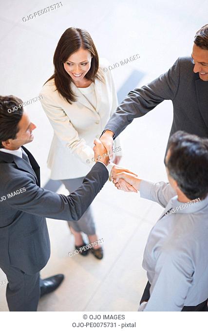 Business people holding hands together in office