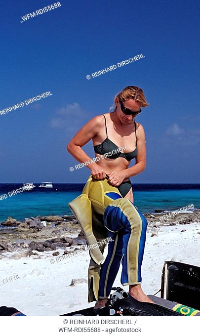 Woman preparing to dive on the beach, Caribbean Sea, Netherlands Antilles, Bonaire
