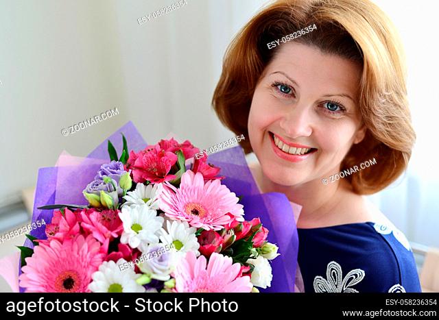 Woman with a bouquet of a flowers in the room