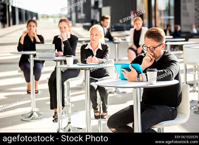 Lot of business people sitting in cafe of modern office building