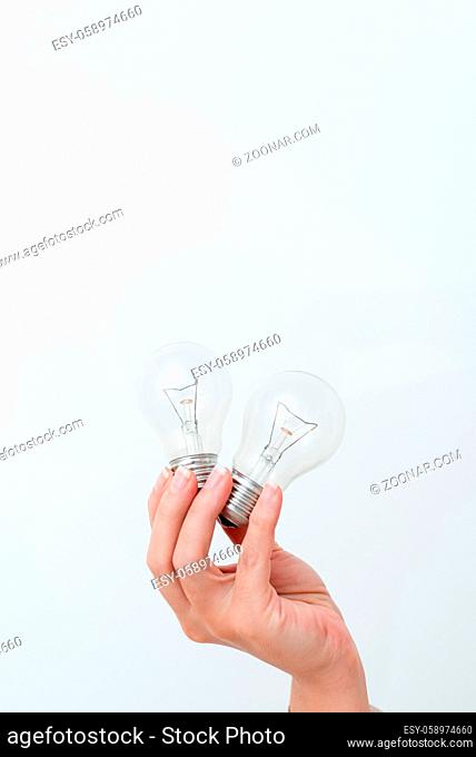 Woman Hands Holding Lamp Presenting Ideas For Project, Man Palm Showing Bulbs And New Technologies, Two Held Lightbulbs Exhibiting Another Opinion