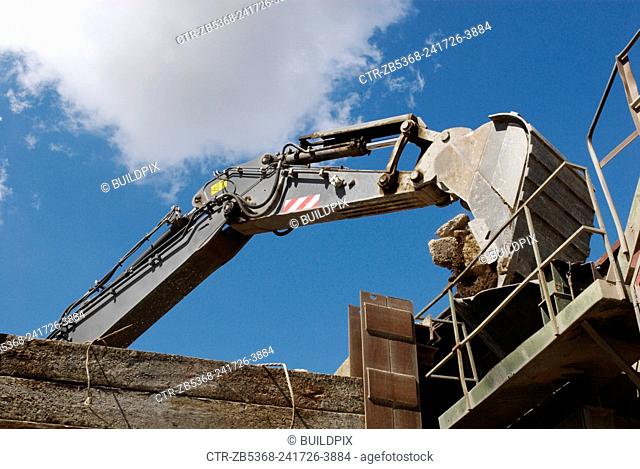 Loading rubble onto a conveyor belt at an aggregate plant, Greenwich, South-East London, UK