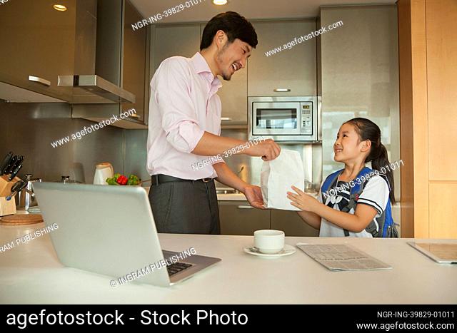 Father giving breakfast to his daughter
