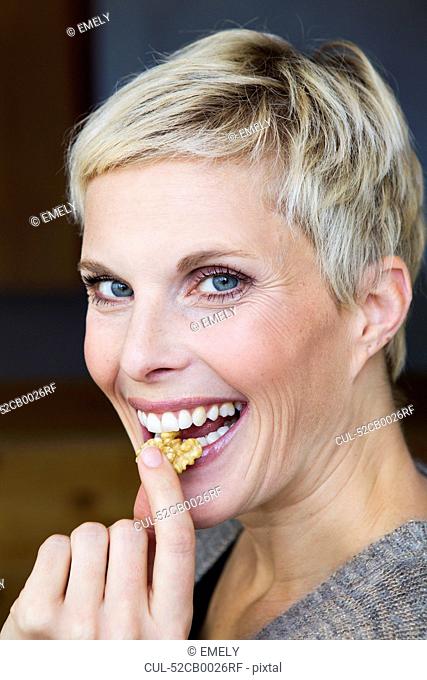 Smiling woman eating snack