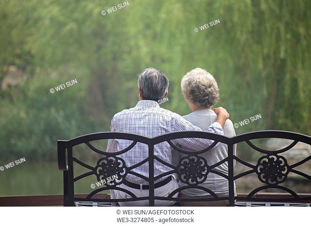 Elderly couple outdoors, sitting on bench