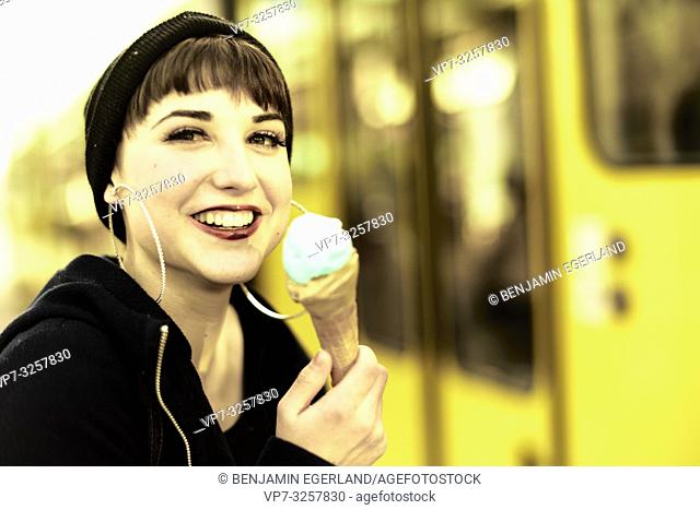 lively woman with ice cream cone during warm winter day, in city Cottbus, Brandenburg, Germany