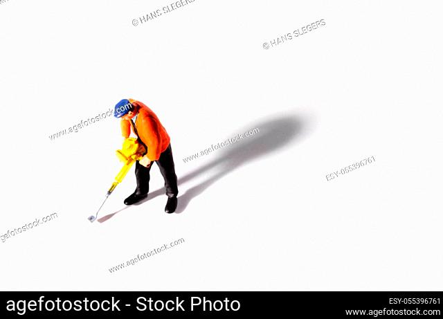 Little People Builder worker with pneumatic hammer drill equipment on white background. Shot from above with shadow