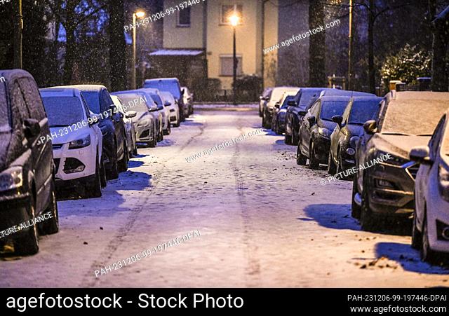 06 December 2023, Berlin: A first track can be seen in the snow on a road in Karlshorst. There is a risk of black ice due to the cold and wet winter weather