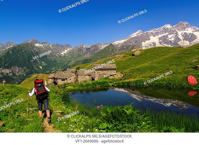 Hikers in the alpe Campo with Monte Rosa reflected on the lake, Alagna Valsesia, val d'Aosta, Italy, europe