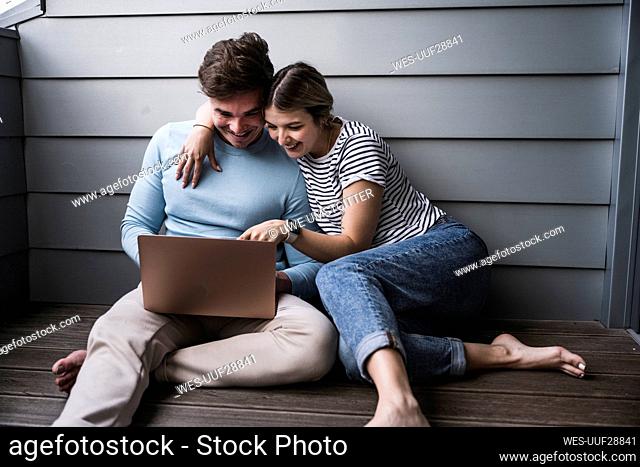 Happy young couple using laptop together